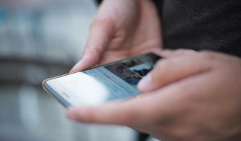 person using smartphone shallow focus photography